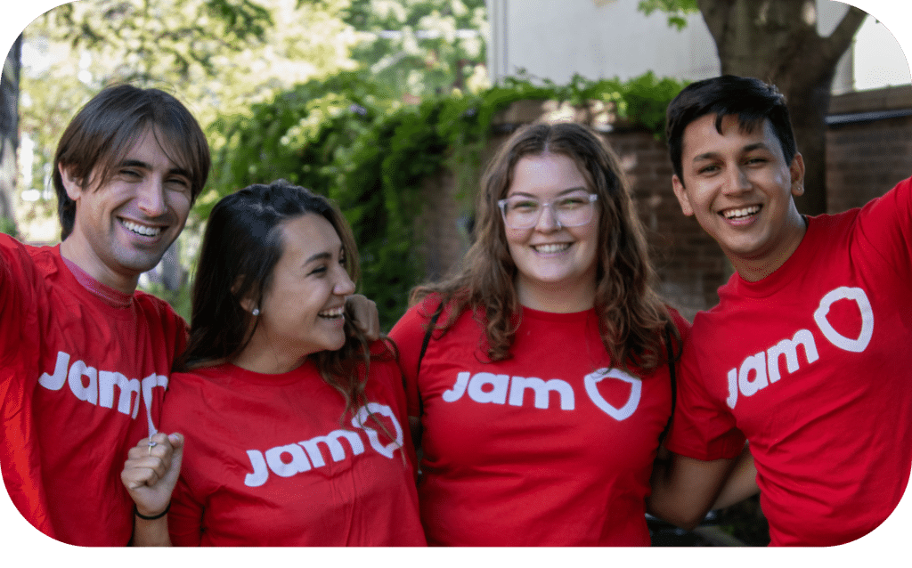 4 teammates wearing red JAM tshirts share a laugh at an in-person team buildling event 